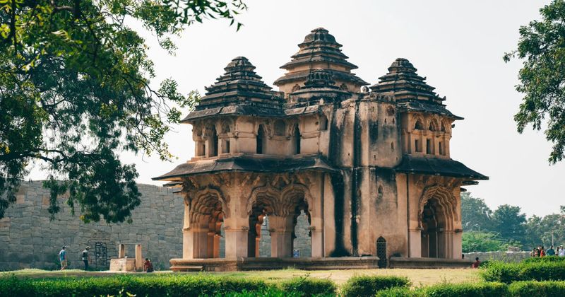 The Lotus Mahal (Kamal Mahal) in Hampi's Zenana Enclosure — the 16th-century pavilion combines pointed Indo-Islamic arches with corbelled Hindu bracketing in a deliberate architectural synthesis; entry included in the ₹600 Elephant Stables/Zenana Enclosure ticket for foreigners