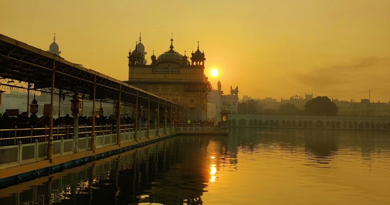 The Golden Temple (Harmandir Sahib) at sunrise in Amritsar — the gold dome and upper panels were donated by Maharaja Ranjit Singh, who had approximately 750 kg of gold applied in 1830; the temple has been destroyed multiple times by Afghan invaders and always rebuilt; it has been attacked by the Indian Army in 1984 and always rebuilt