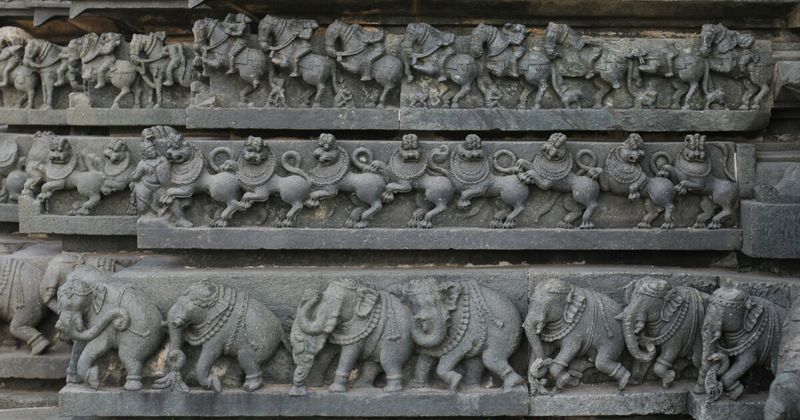 Hoysala temple carvings at Belur or Halebidu — continuous figural carving on every surface; foreigners ₹300–₄00; the soapstone allows detail impossible in granite.