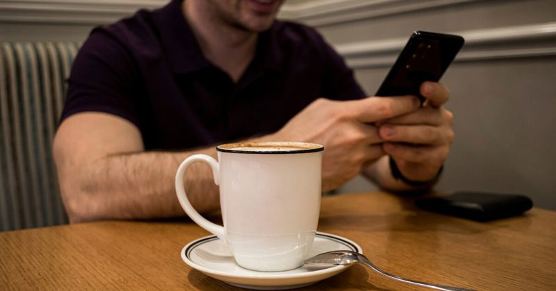 Person planning USA to India flight booking window with phone and calendar — best time to book 2026