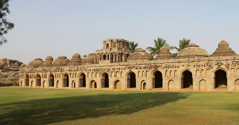 The Elephant Stables (Gajashaala) in Hampi — 11 chambers with deliberately varied dome styles, each built to house the royal war elephants; entry ₹600 foreigners (covers Lotus Mahal and Zenana Enclosure on same ticket); open 6am–6pm