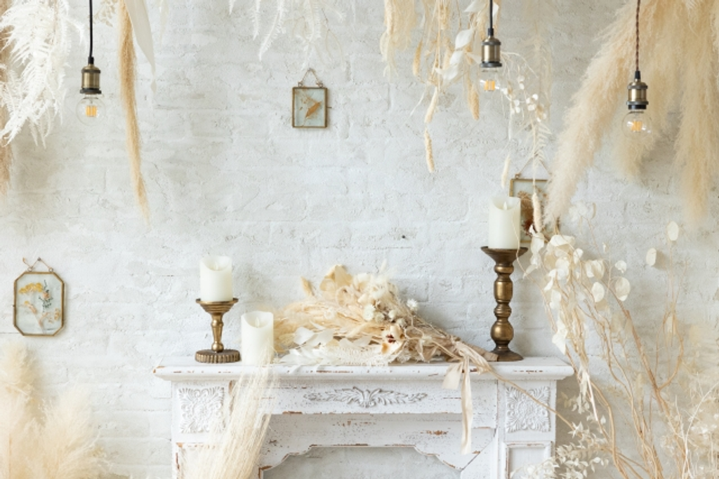 Rustic white interior with vintage mantle, dried flowers and pendant lights.