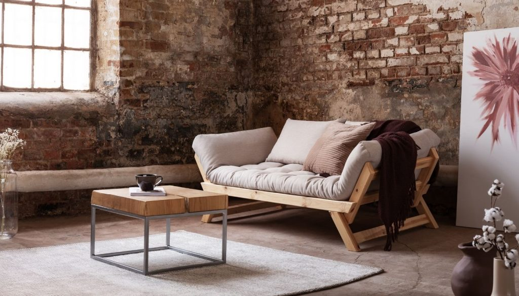 Minimalist futon in rustic brick room with simple decor.