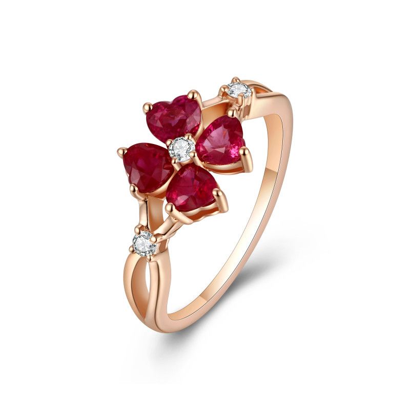 Four heart-cut rubies forming a flower with natural diamond accents in an 18k rose gold ring