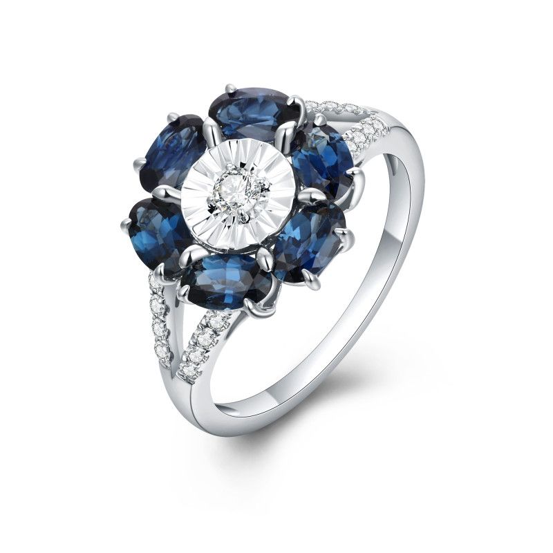 Oval blue sapphire floral ring with a natural diamond centre and diamond-set shoulders in 18k gold