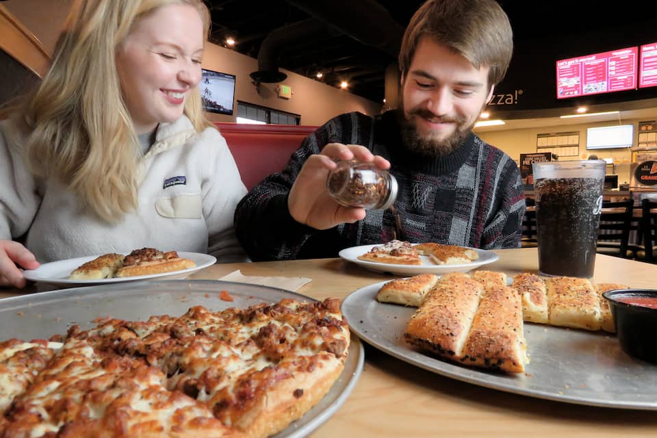 Two people enjoying a meal at Westside Pizza