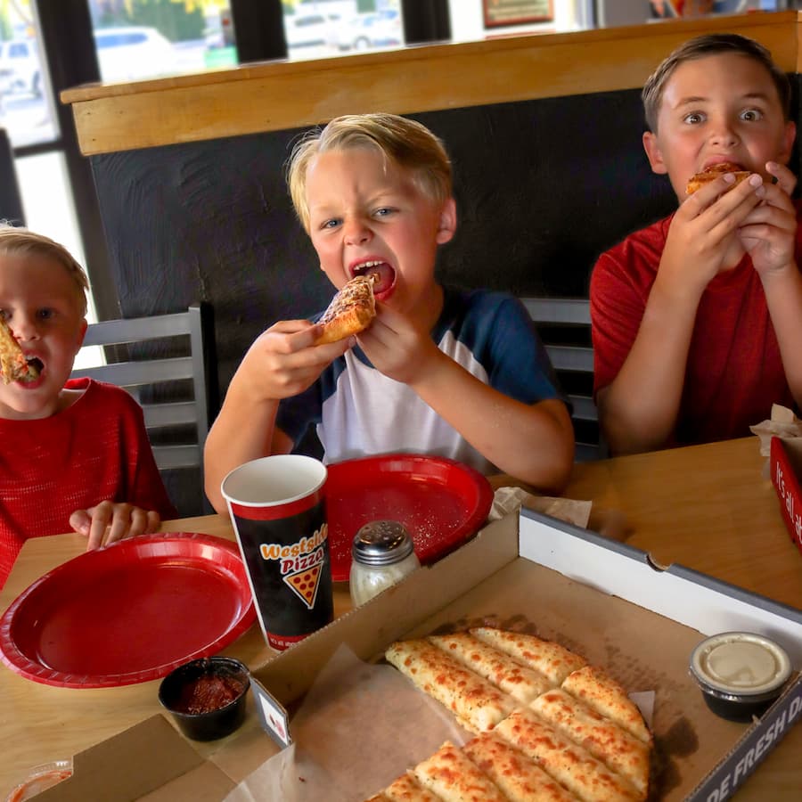 Three children eating Westside Pizza