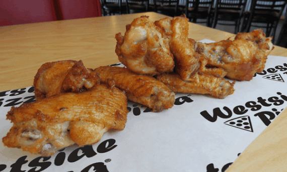 A row of plain chicken wings on Westside Pizza branded paper