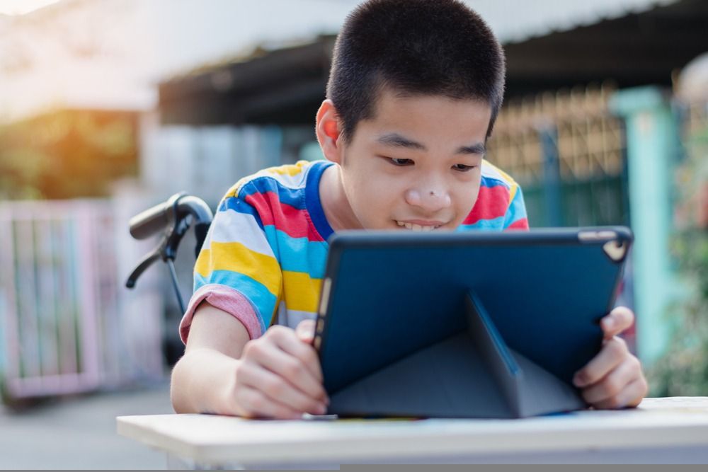 Boy reading in a weelchair