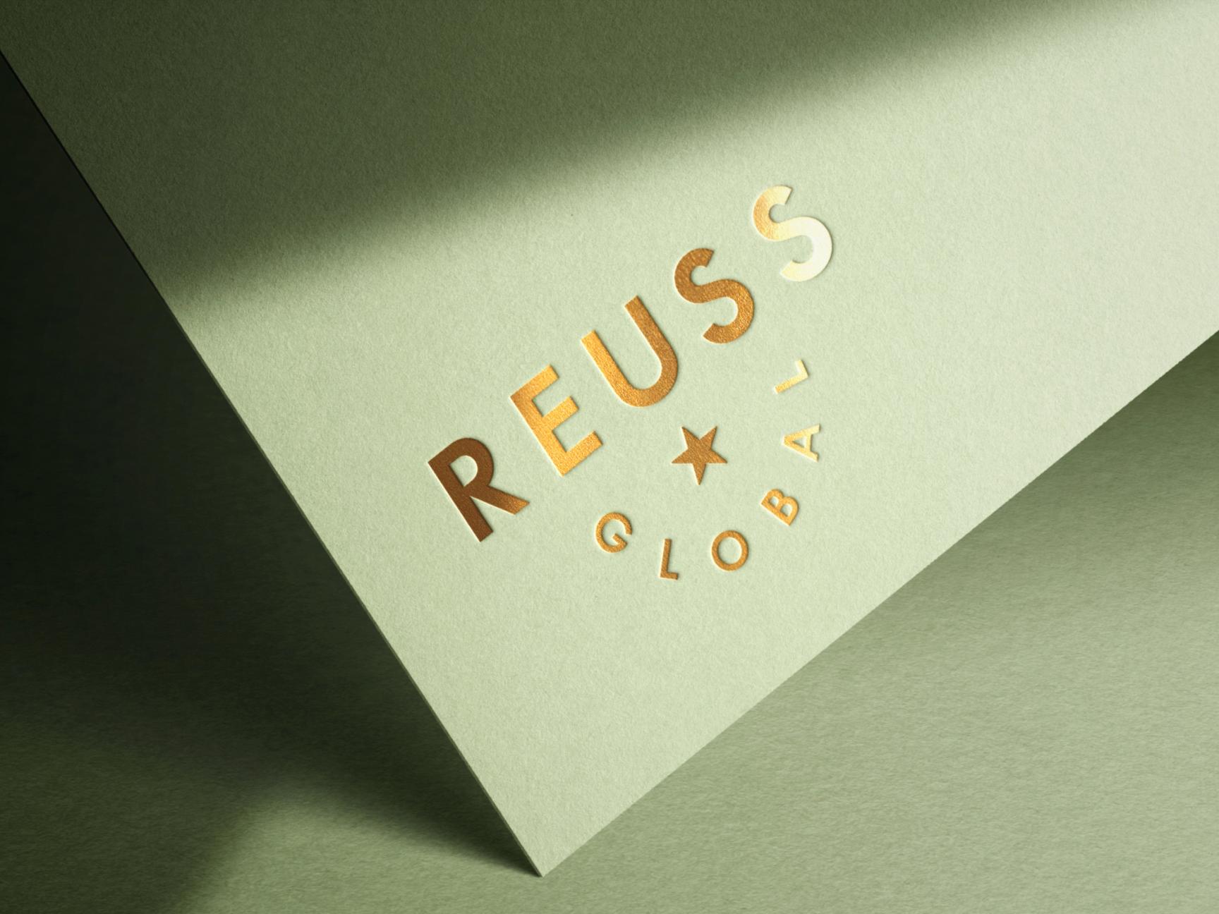 Elegant logo design for Reuss Global with gold foil effect on "REUSS" and a minimalist star symbol.