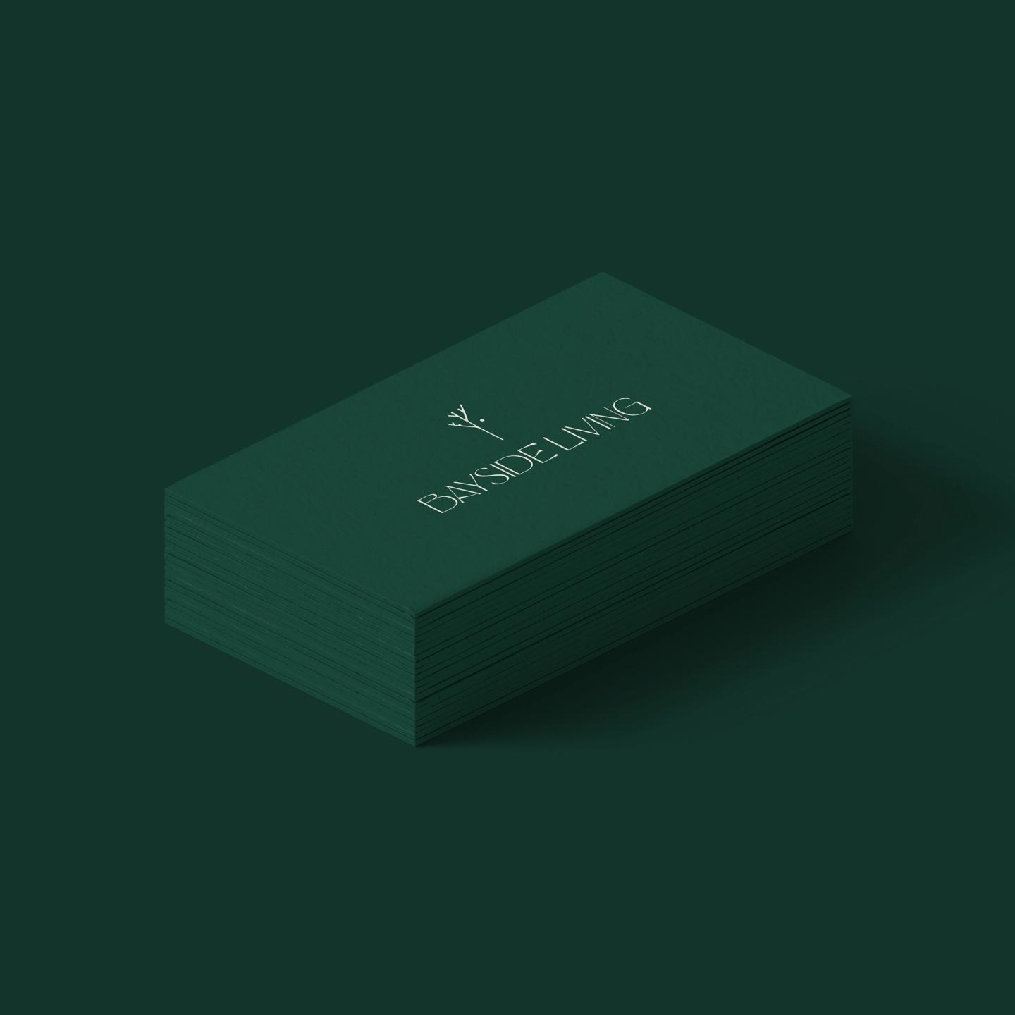 Elegant business cards for Bayside Living with minimalist logo in white on dark green background.