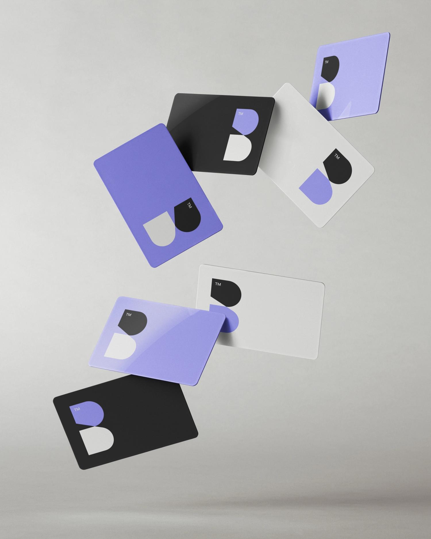 Floating business cards featuring modern logo design with purple, black, and white color scheme.
