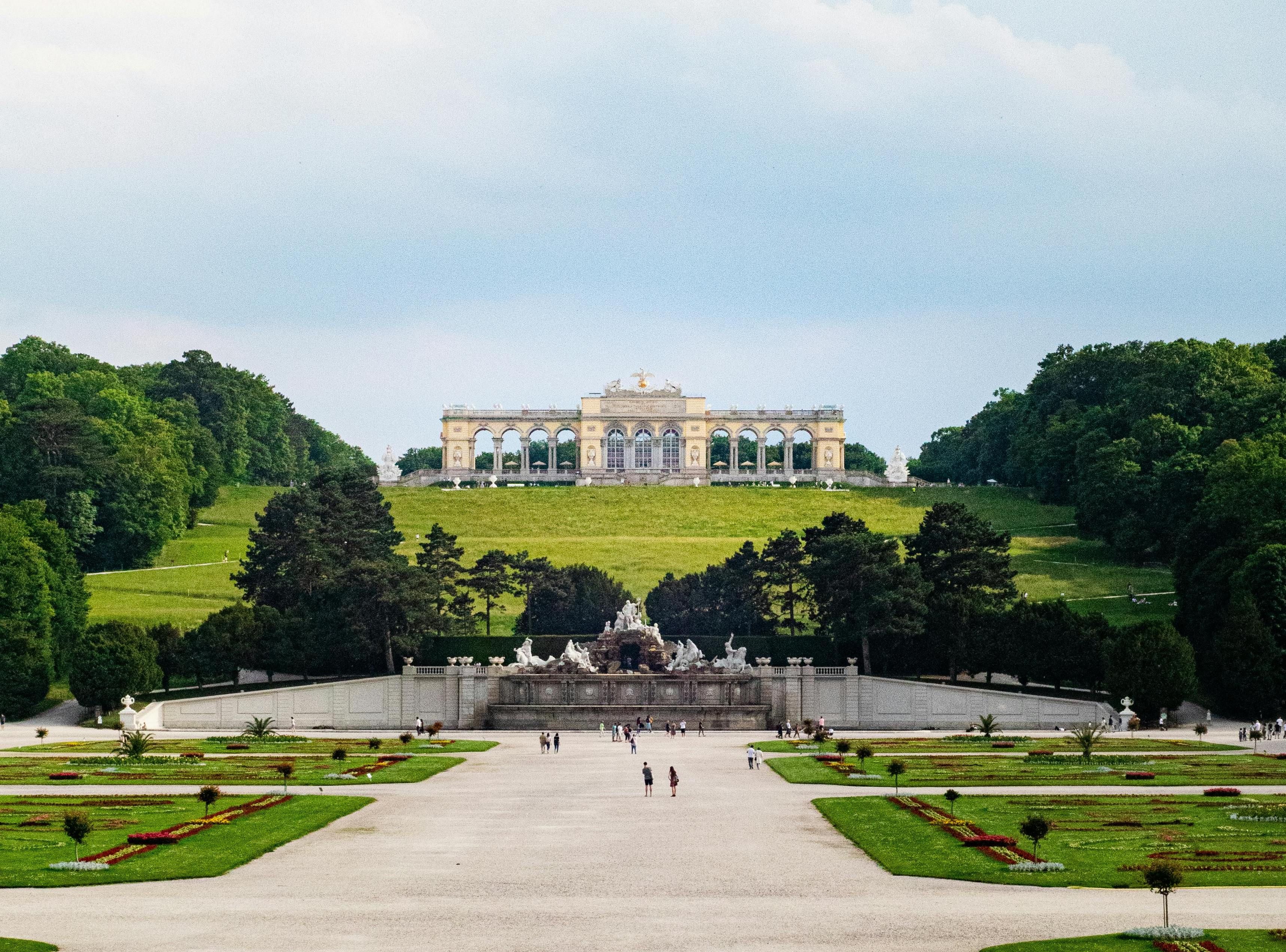 Weitläufige Gartenanlage mit zentralem Weg und Gloriette im Hintergrund.