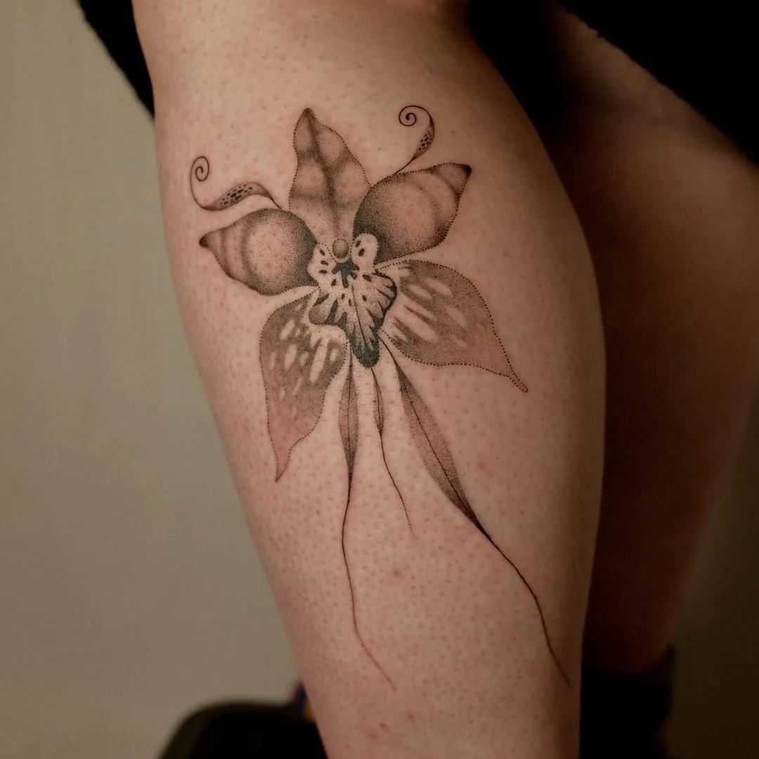 Dotwork alien orchid tattoo with curling tendrils on a calf