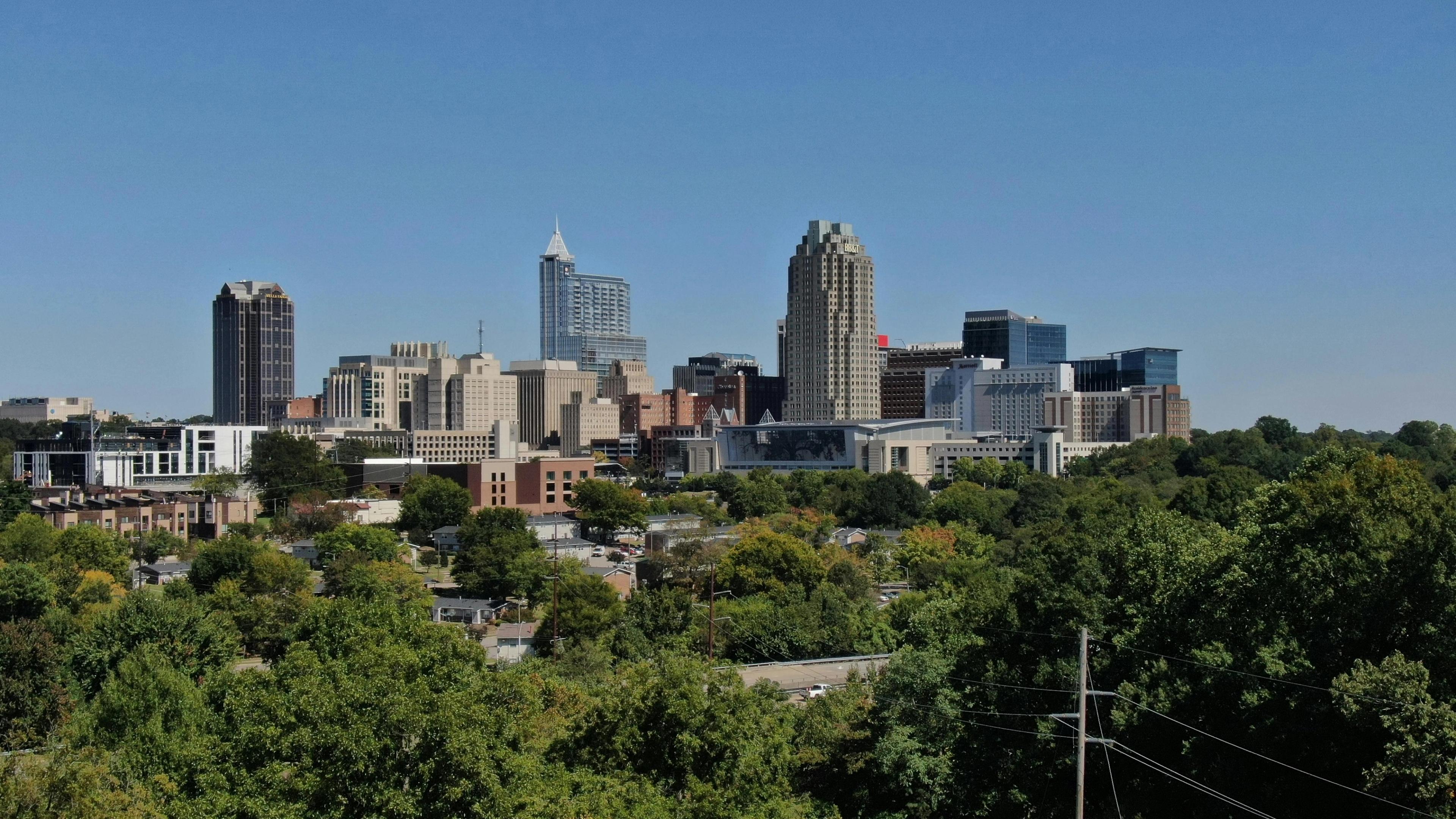 View of Raleigh skyline with tall buildings and lots of green trees