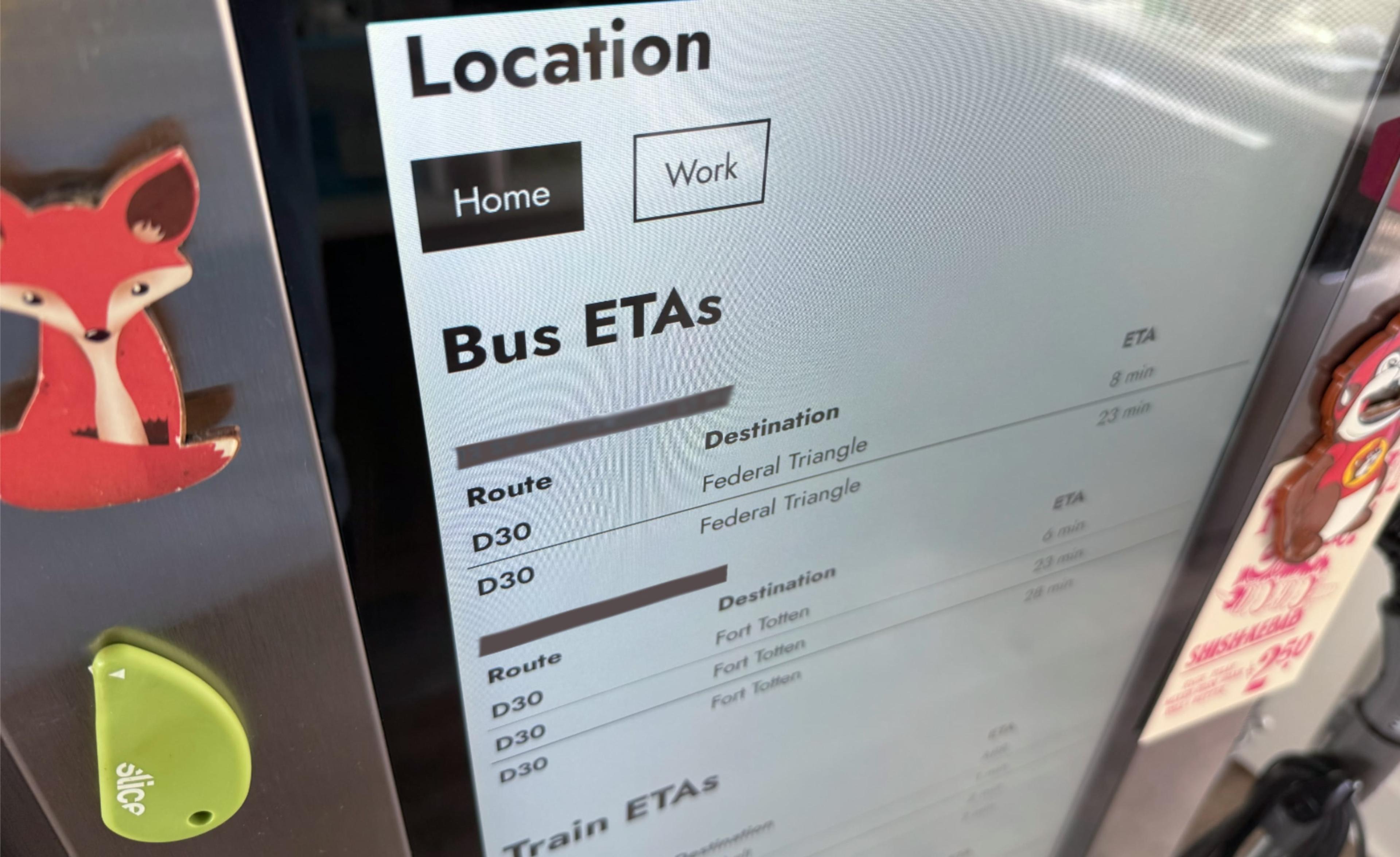 Image of a screen on a refrigerator, showing Locations for Home and Work, Bus ETAs (routes D30, destination Federal Triangle, and ETA times in minutes). Nearby on the fridge are magnets: a Fox, a Buc-ees mascot bottle opener, and a Slice package opening tool.