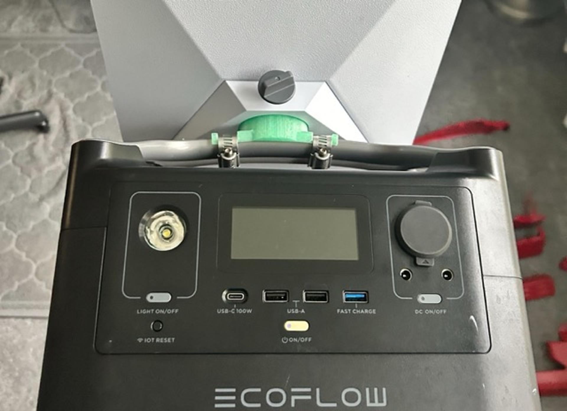 Close-up of an EcoFlow Pro battery generator, with a green plastic mount attached to its top handle, allowing a Starlink satellite receiver to sit on top.
