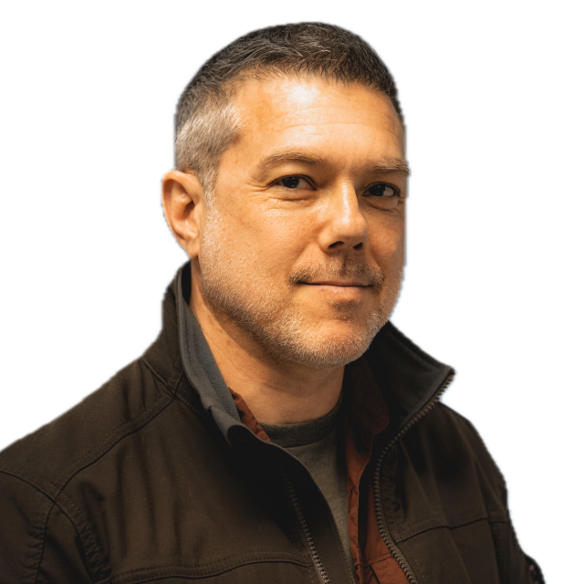 A man wearing a black jacket with the collar turned up.