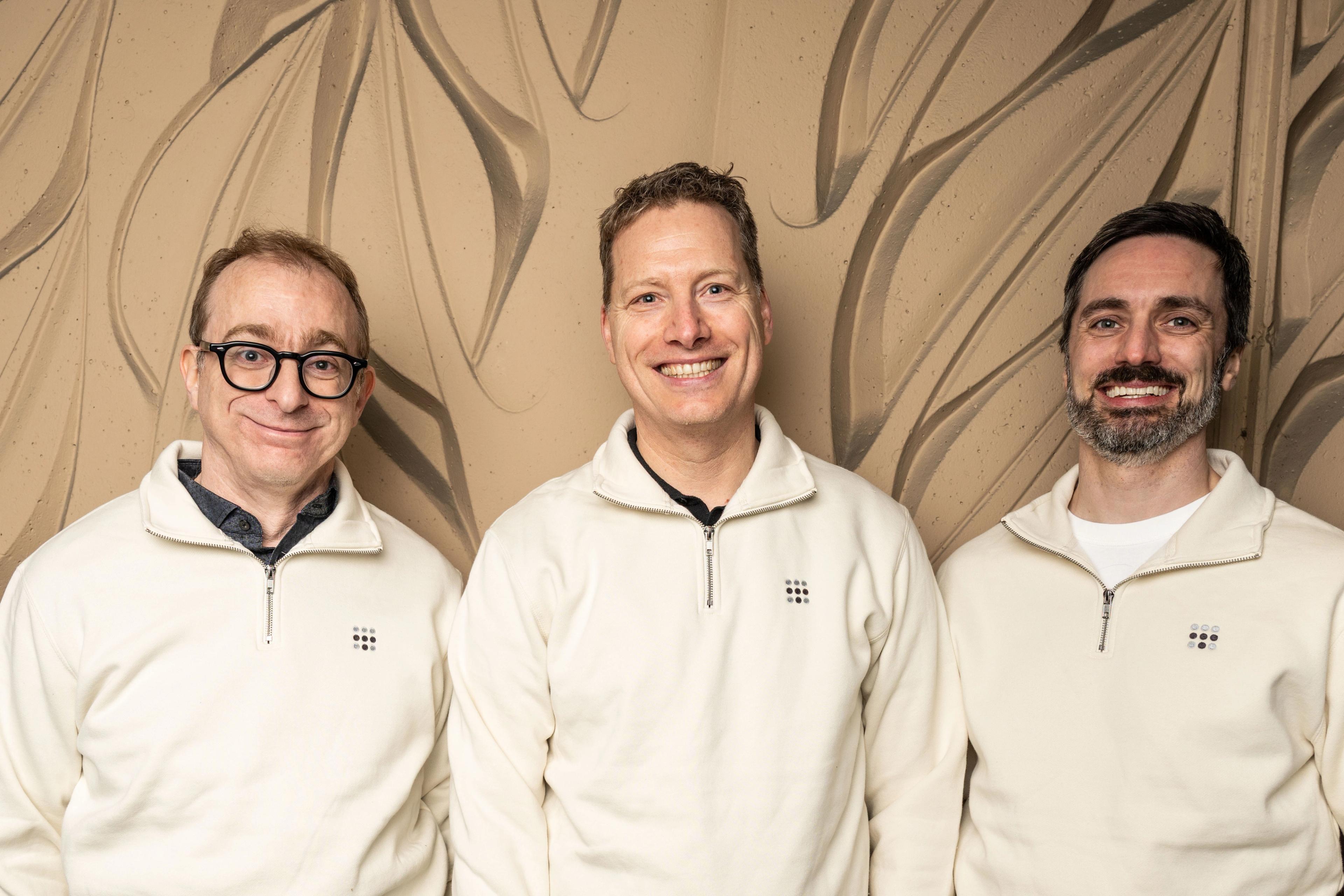 Avery, Andree and David standing together in Tailscale sweaters