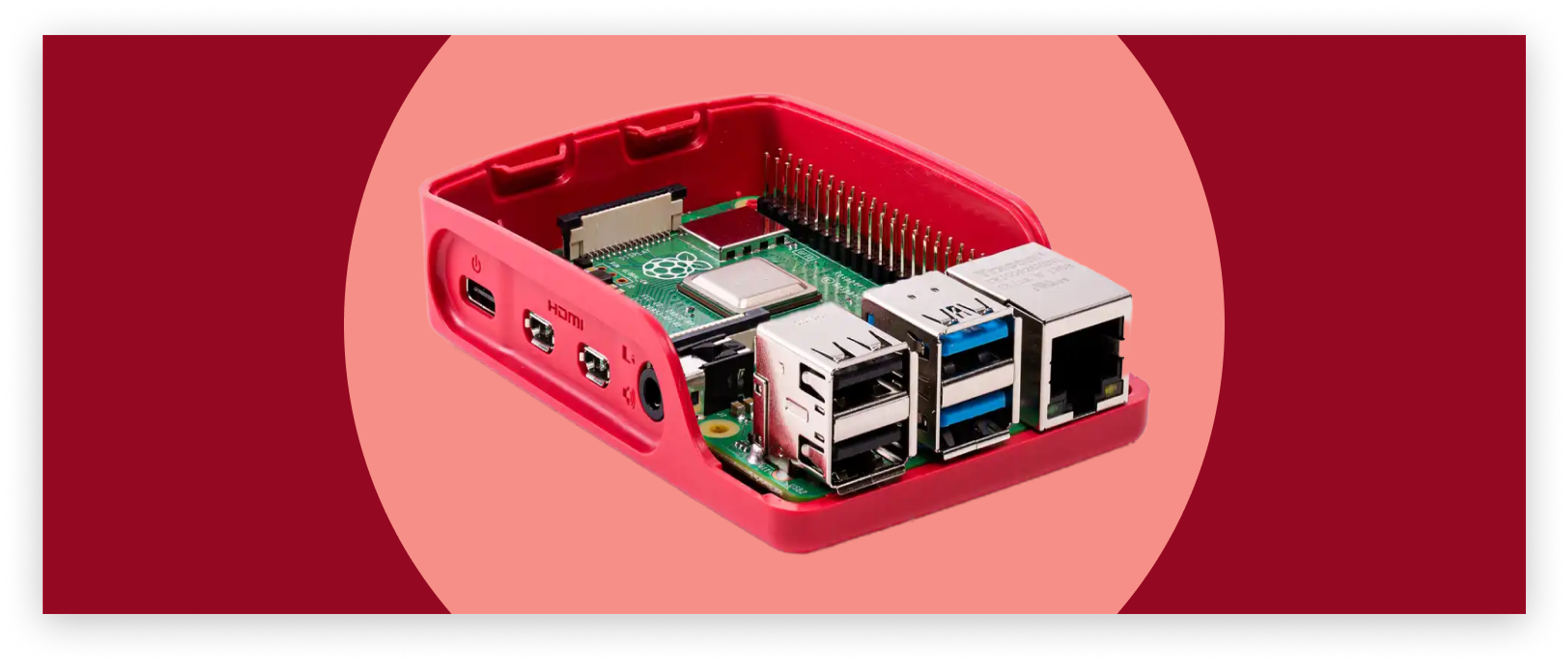 A Raspberry Pi 4b board, placed inside the bottom half of the official Raspberry Pi 4b case (red plastic, curved edges), with its ports facing toward the viewer at an isometric angle. The Pi is inside a light red/pink circle, inside a darker red background.