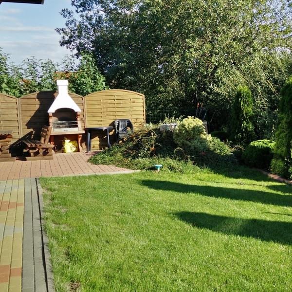Ogród z murowanym grillem w letnim słońcu