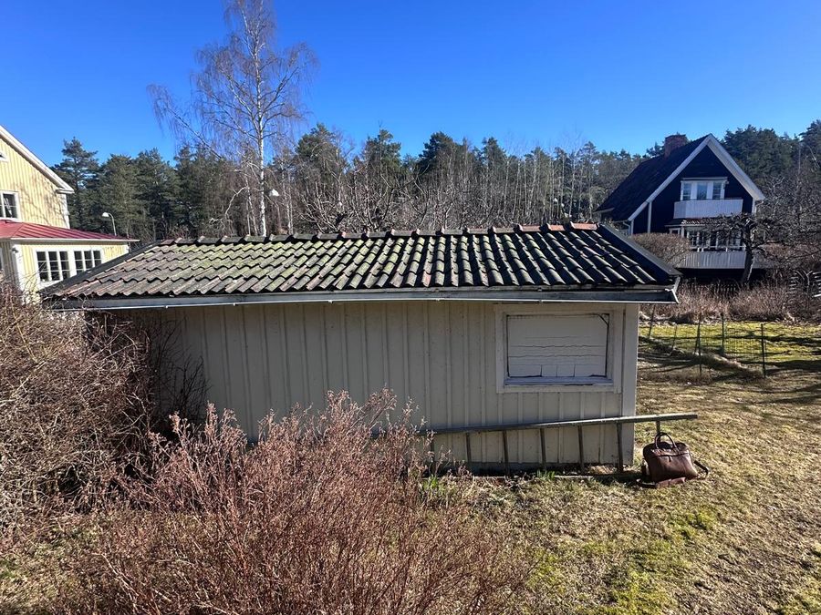 Gammalt garage med kraftigt mossbevuxet tegeltak