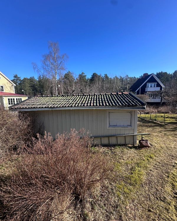 Gammalt garage med kraftigt mossbevuxet tegeltak