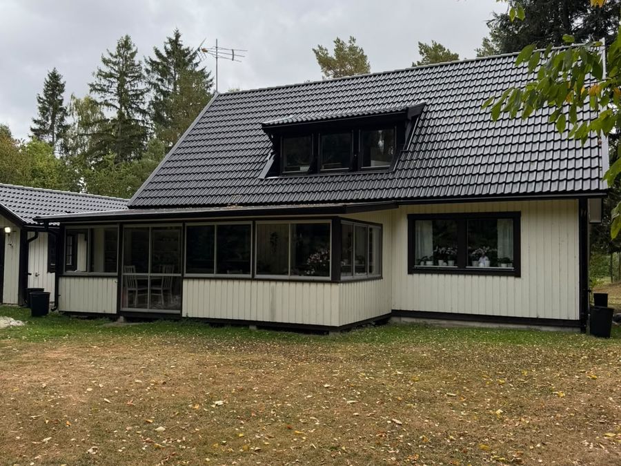Takkupa och takfot med nytt svart betongtak och svarta hängrännor efter omläggningen i Flen