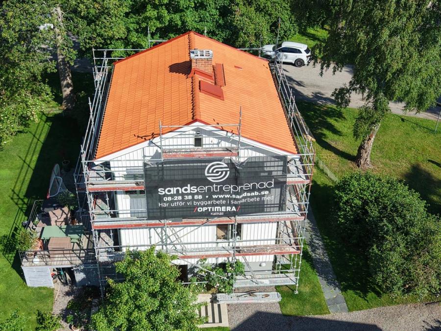Det färdiga taket och fasaden med Sands Entreprenads banderoll på ställningen