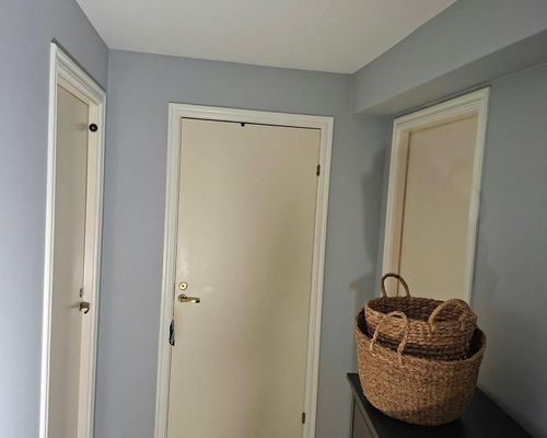 Hallen efter målning med nymålade väggar och vita dörrar