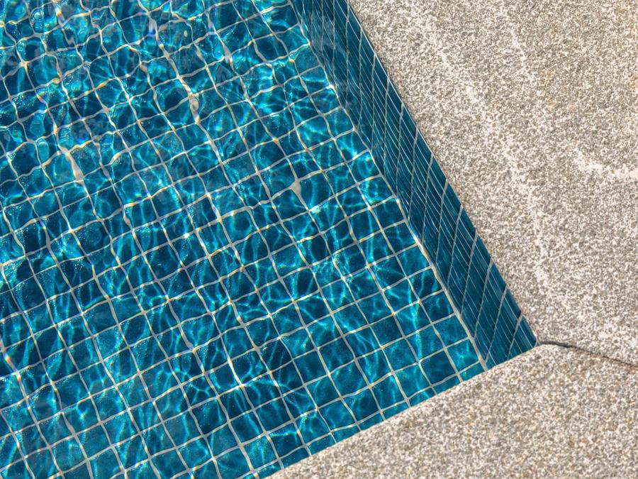 Poolens glasmosaik i turkos, detaljbild av kaklet under vattenytan