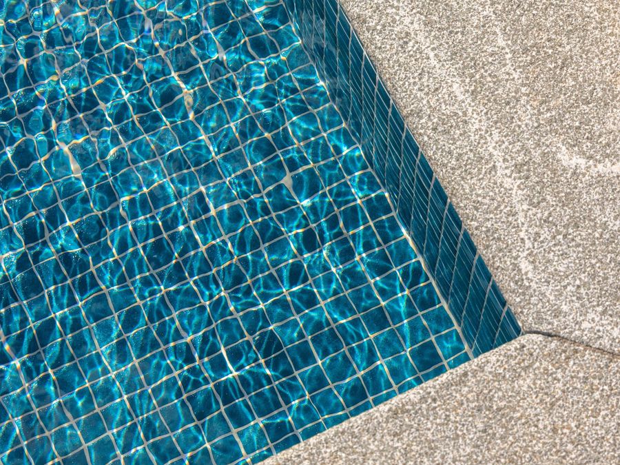 Poolens glasmosaik i turkos, detaljbild av kaklet under vattenytan