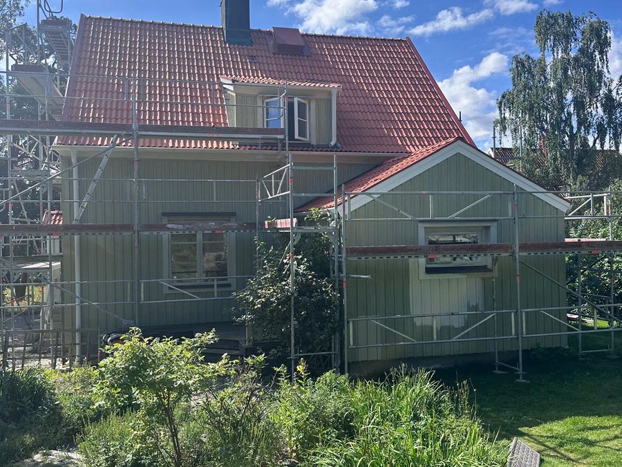 Sida av villa med nytt tegeltak och ställning