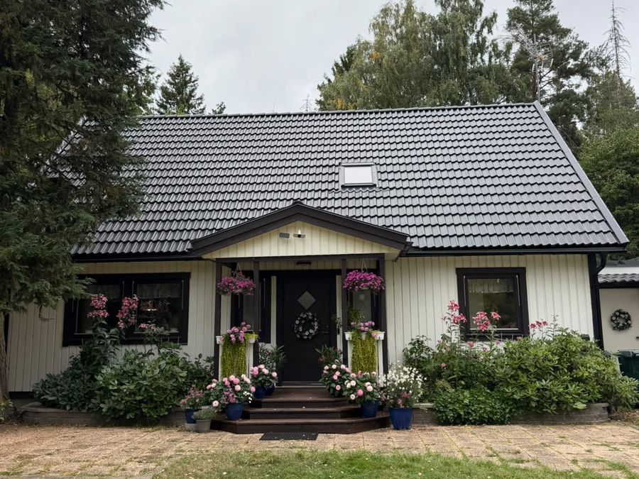 Entrésidan på villan i Flen efter takbytet, med nytt svart betongtak och nya vindskivor
