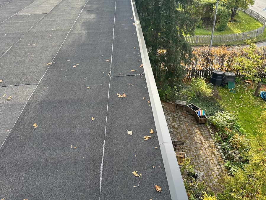 Det färdiga papptaket med ny svart krönplåt längs takfoten
