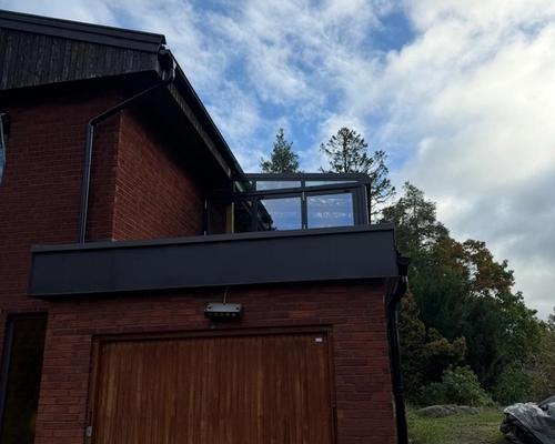 Garagehörnet efter ombyggnaden med nya plåtbeslag och terrassen ovanför