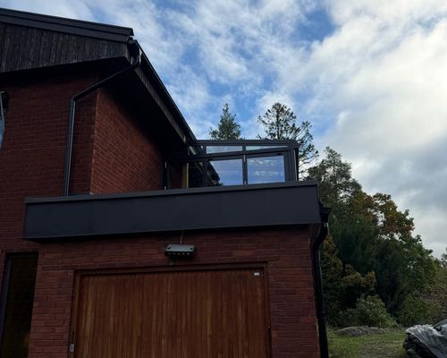 Garagehörnet efter ombyggnaden med nya plåtbeslag och terrassen ovanför