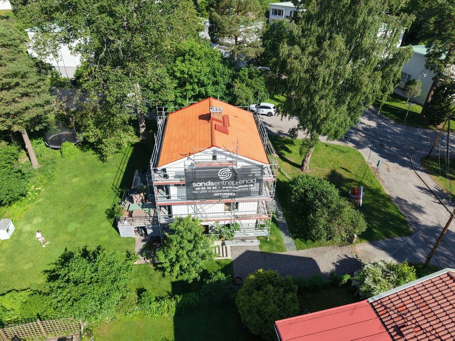 Bred drönarbild på nytt tegeltak och omgivande trädgård