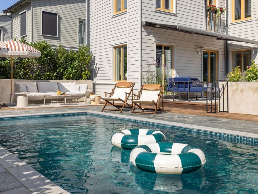Poolen med solstolar och badringar en solig sommardag