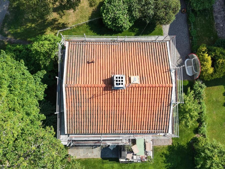 Det gamla tegeltaket ovanifrån med tydligt slitna och missfärgade pannor