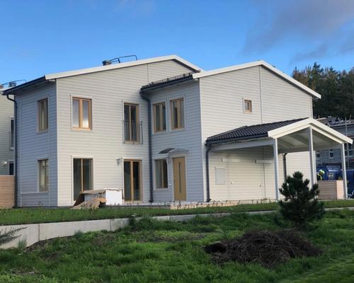 Tomten före arbetet, en tom gräsyta längs husets baksida