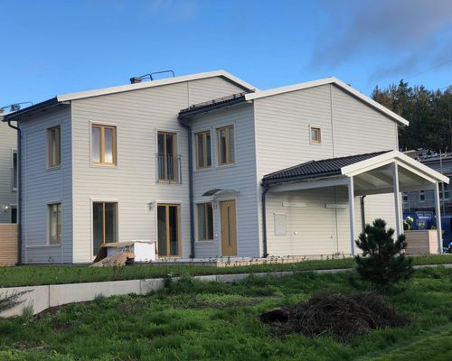 Tomten före arbetet, en tom gräsyta längs husets baksida