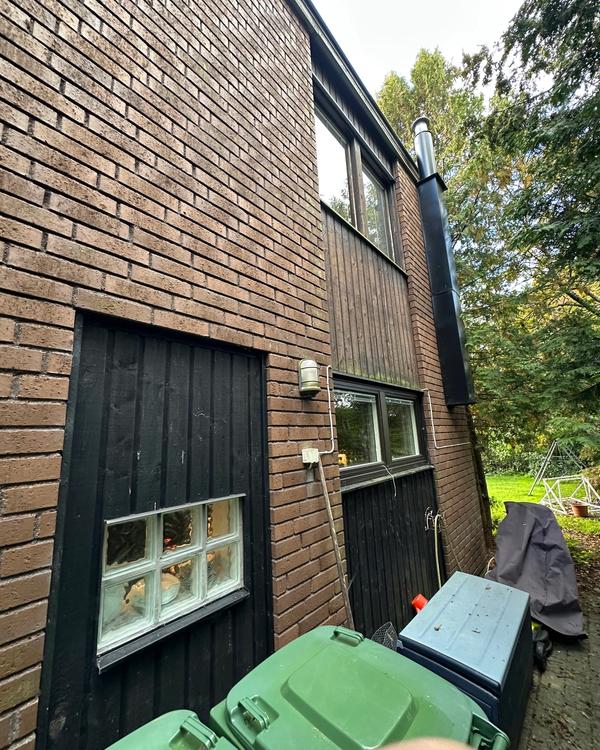 Husets baksida innan renovering, gammalt tegeltak och slitna träpaneler