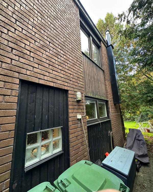 Husets baksida innan renovering, gammalt tegeltak och slitna träpaneler