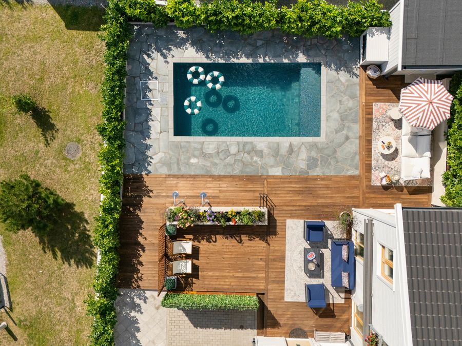 Hela anläggningen ovanifrån med pool, loungedel och planteringar