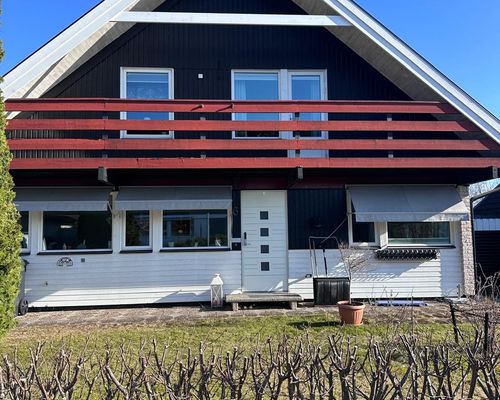 Volmvägen 6 före renovering, framsidan med vit panel och rött räcke
