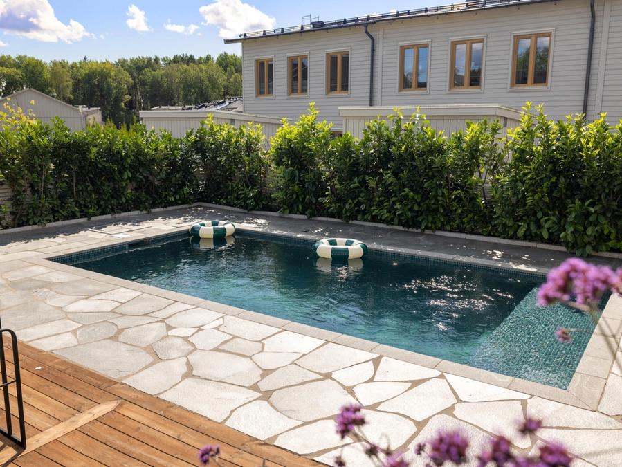 Poolen omgiven av natursten i oregelbundet mönster