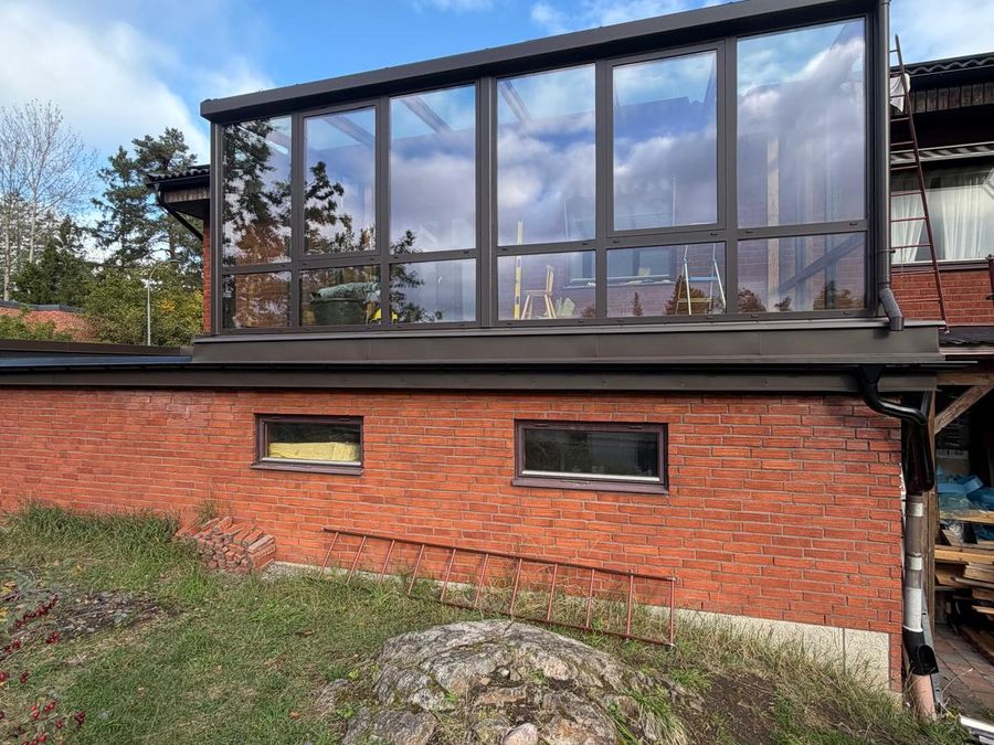 Samma vy efter ombyggnaden, med färdig inglasad terrass ovanpå garaget