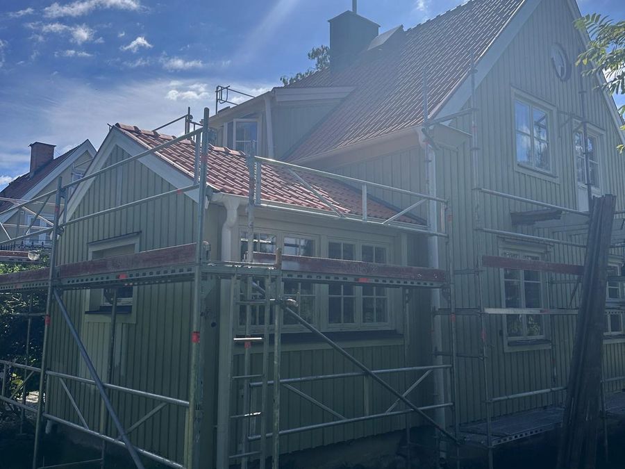 Baksida av villa med nytt tegeltak och omgivande trädgård