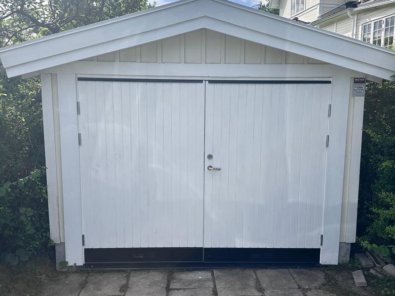 Ny vit garageport på renoverat garage i Bromma